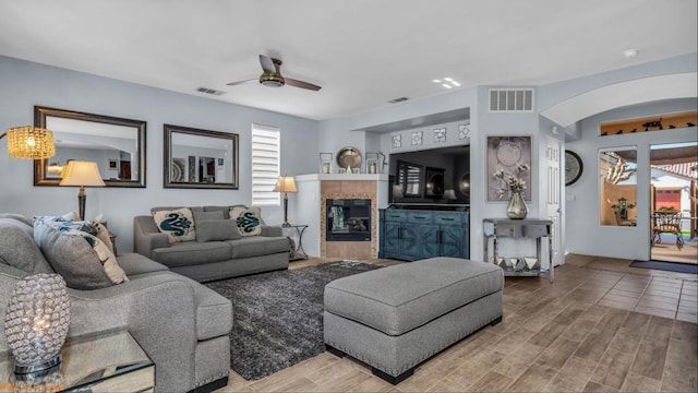 living room featuring ceiling fan, hardwood / wood-style floors, and a fireplace