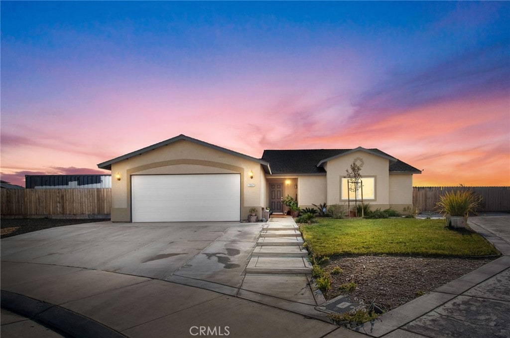 single story home featuring a garage and a yard