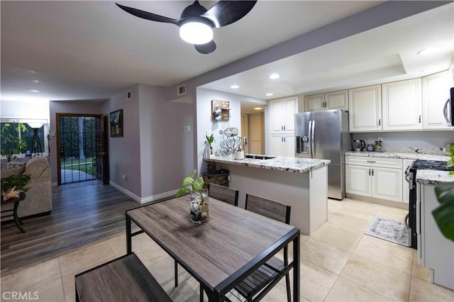 kitchen featuring sink, light tile patterned floors, ceiling fan, light stone counters, and stainless steel appliances