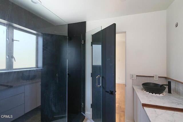 bathroom with vanity, wood-type flooring, and walk in shower