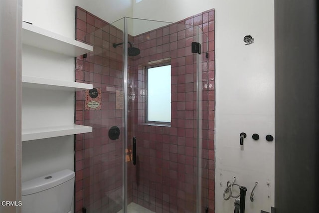 bathroom with a shower with door and toilet