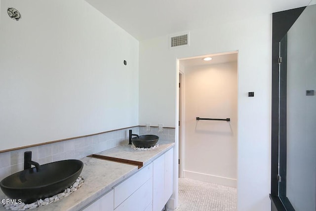 bathroom with vanity and decorative backsplash