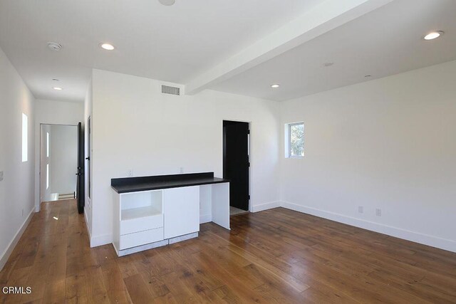 kitchen featuring beam ceiling and dark wood-type flooring