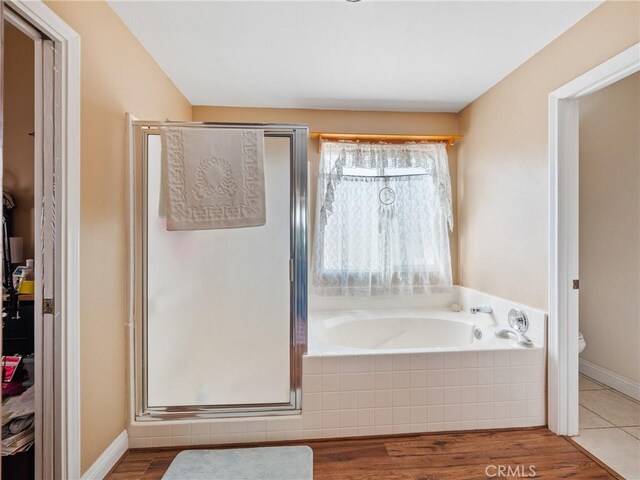 bathroom with hardwood / wood-style flooring, plus walk in shower, and toilet