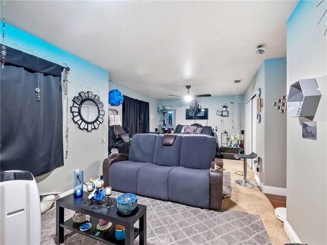 living room featuring ceiling fan and carpet