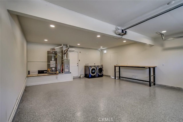 garage with a garage door opener, separate washer and dryer, heating unit, and strapped water heater