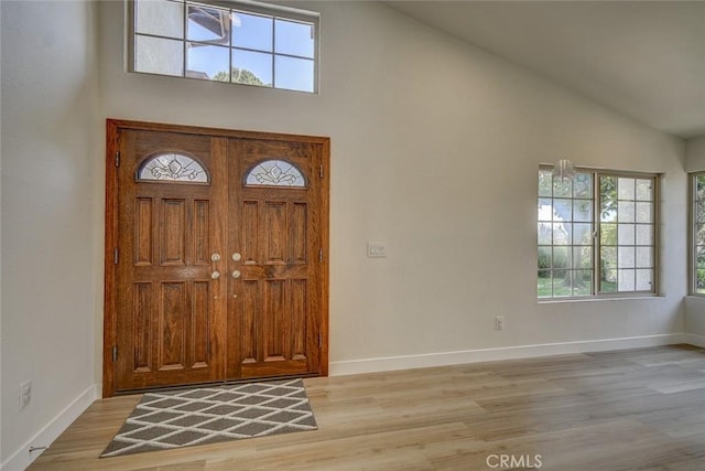 entryway featuring high vaulted ceiling and light hardwood / wood-style floors