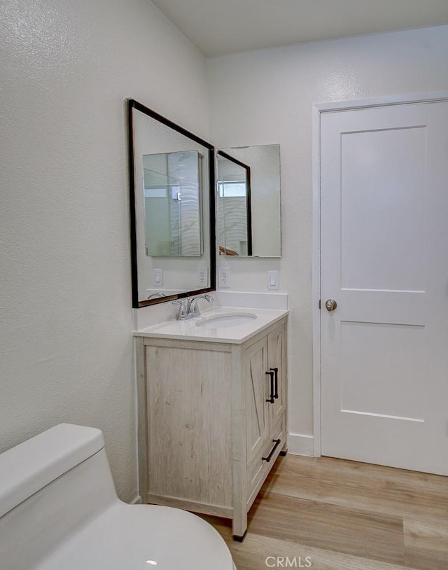 bathroom featuring vanity, hardwood / wood-style floors, and toilet