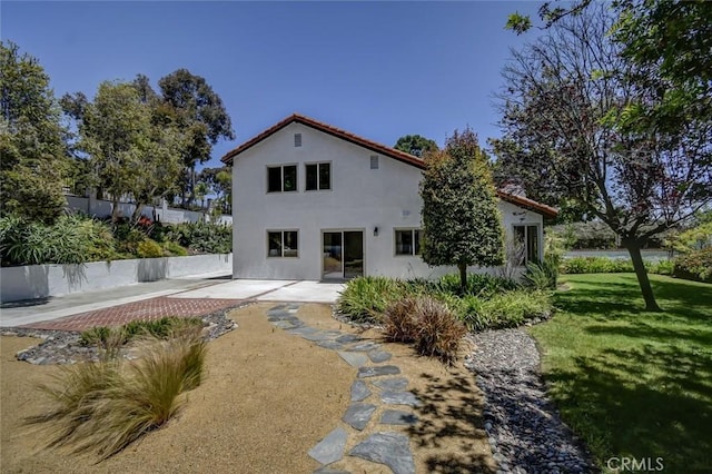 back of property featuring a patio area and a lawn