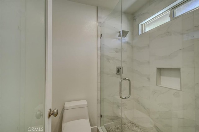 bathroom featuring an enclosed shower and toilet