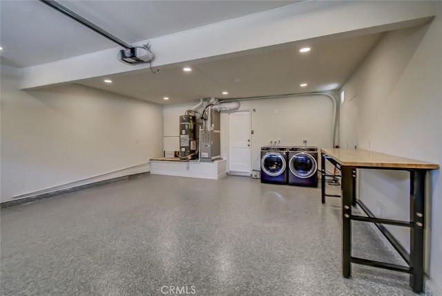 garage featuring independent washer and dryer, a garage door opener, and electric water heater