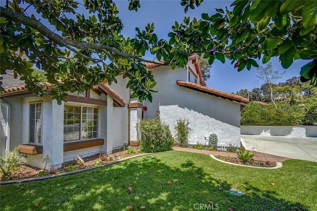 view of property exterior featuring a yard and a patio