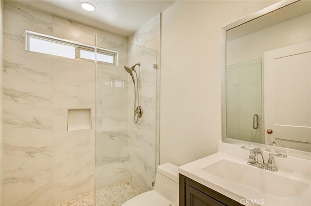 bathroom with vanity, toilet, and an enclosed shower