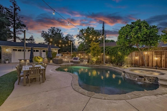 pool at dusk with an in ground hot tub and a patio area