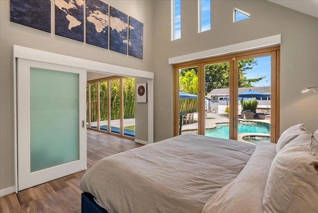 bedroom with multiple windows, access to outside, french doors, and wood-type flooring