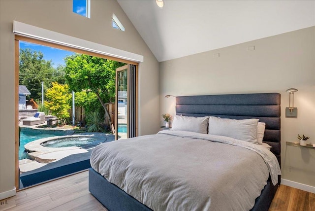 bedroom with light hardwood / wood-style flooring, access to outside, and high vaulted ceiling