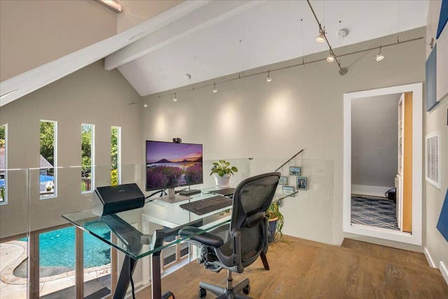 office area featuring hardwood / wood-style flooring, rail lighting, high vaulted ceiling, and beam ceiling