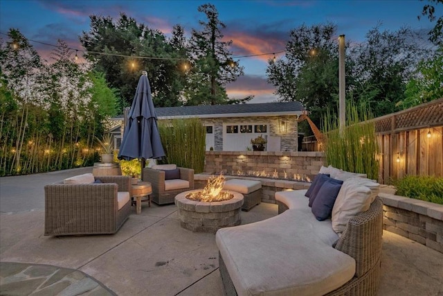 patio terrace at dusk with an outdoor structure and a fire pit