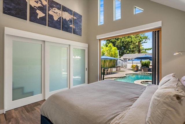 bedroom featuring hardwood / wood-style floors, a high ceiling, and access to outside