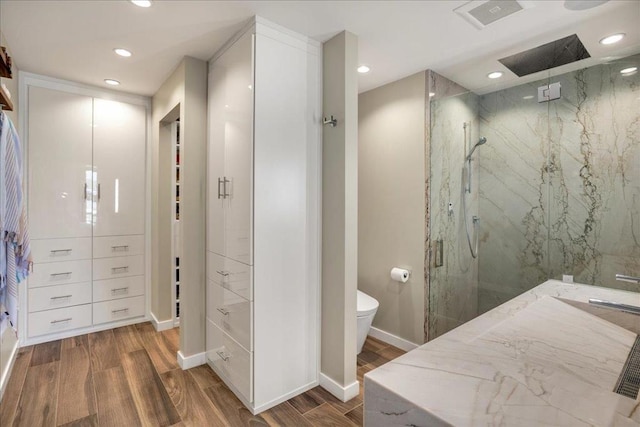 bathroom with hardwood / wood-style flooring, toilet, and an enclosed shower