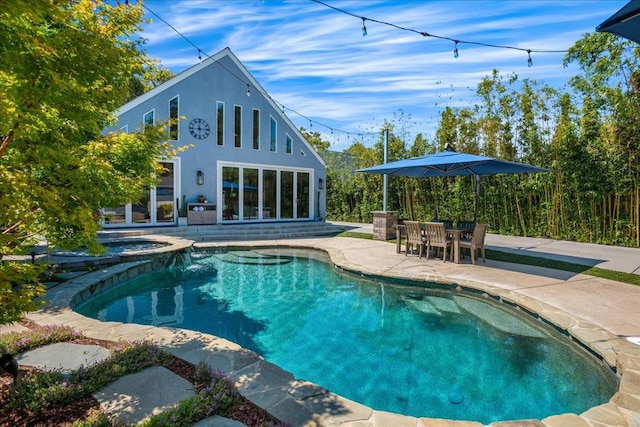 view of pool featuring a patio area and an in ground hot tub