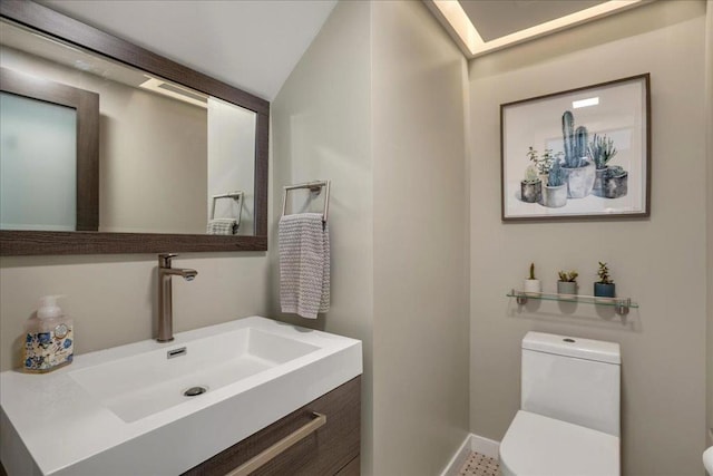 bathroom featuring lofted ceiling, vanity, and toilet