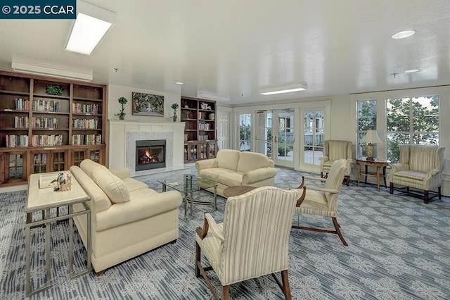 living room featuring french doors, a high end fireplace, carpet flooring, and a wall mounted AC