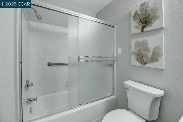 bathroom with shower / bath combination with glass door and toilet