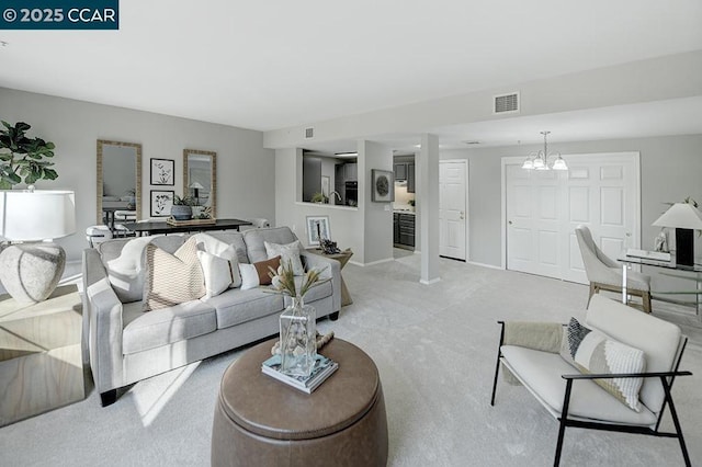 carpeted living room with a chandelier