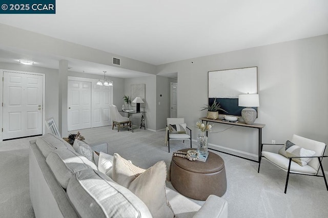 living room featuring light carpet and a notable chandelier