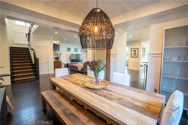 dining room with dark wood-type flooring and an inviting chandelier