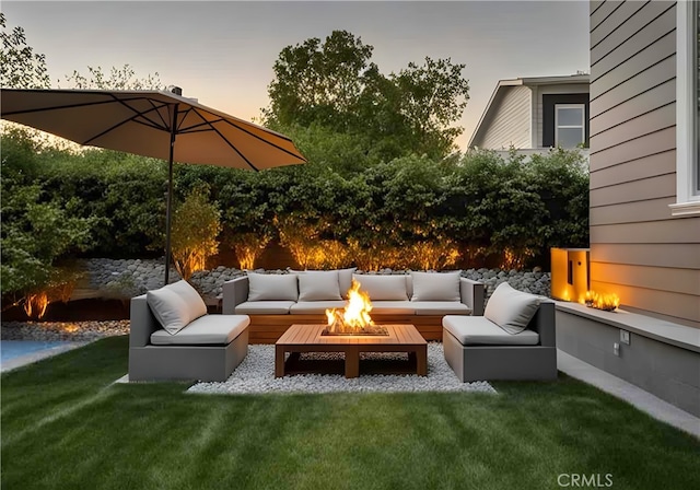 patio terrace at dusk with an outdoor living space with a fire pit and a lawn