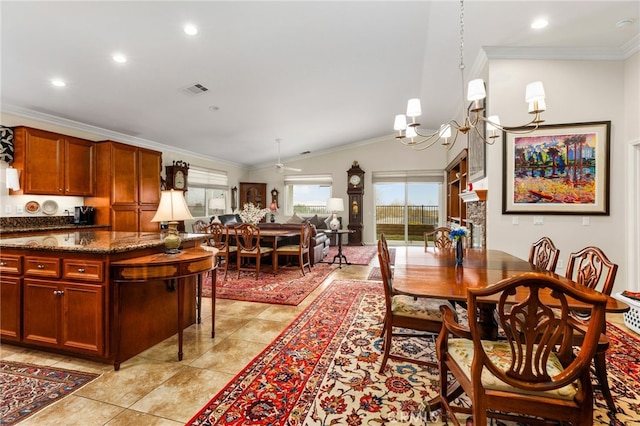 tiled dining room featuring lofted ceiling, ornamental molding, and an inviting chandelier