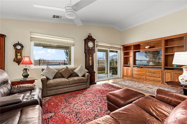 living room featuring ceiling fan, ornamental molding, and lofted ceiling