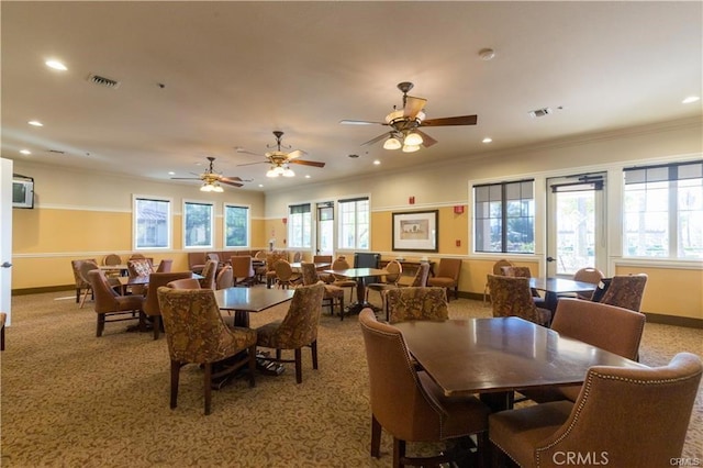 carpeted dining space featuring ornamental molding and plenty of natural light