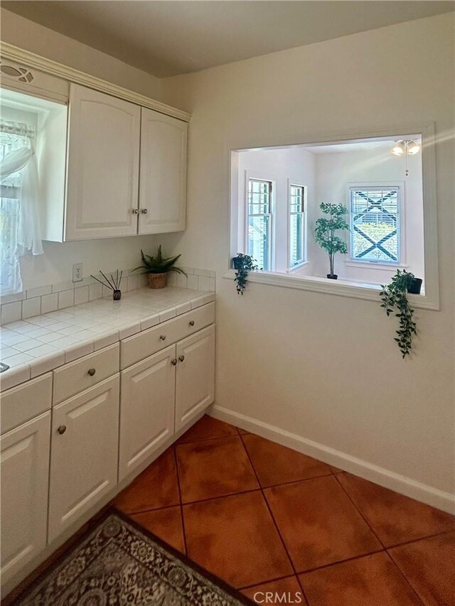 2121 James M Wood Blvd Unit 224, Los Angeles, CA 90006 - kitchen featuring tile counters, white cabinets, and tile patterned flooring