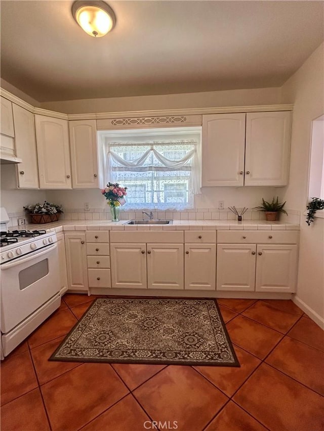 2121 James M Wood Blvd Unit 224, Los Angeles, CA 90006 - kitchen with gas range gas stove, light tile patterned floors, tile countertops, white cabinetry, and under cabinet range hood