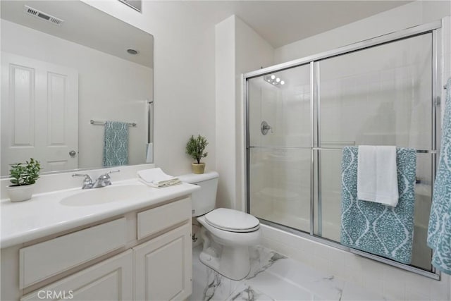 bathroom featuring vanity, a shower with door, and toilet