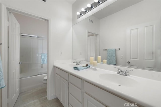 full bathroom featuring vanity, toilet, and combined bath / shower with glass door