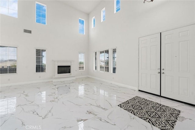 living area with marble finish floor, a premium fireplace, visible vents, and baseboards