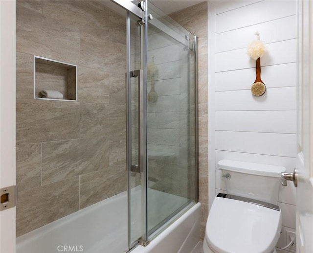 bathroom featuring shower / bath combination with glass door and toilet