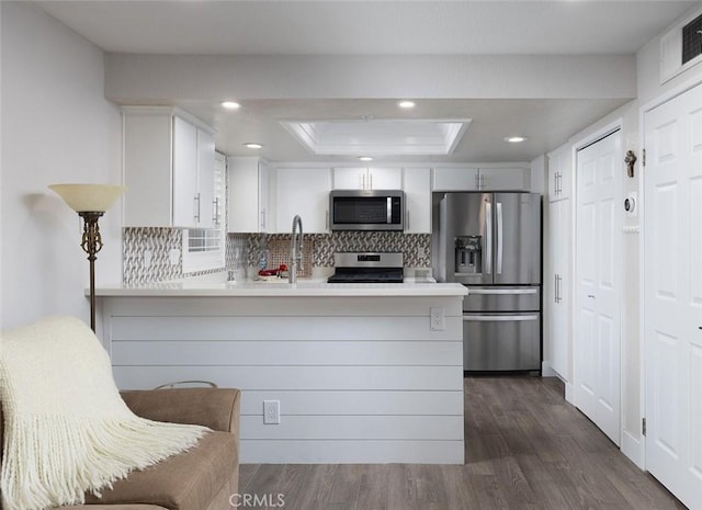 kitchen with kitchen peninsula, white cabinets, and appliances with stainless steel finishes