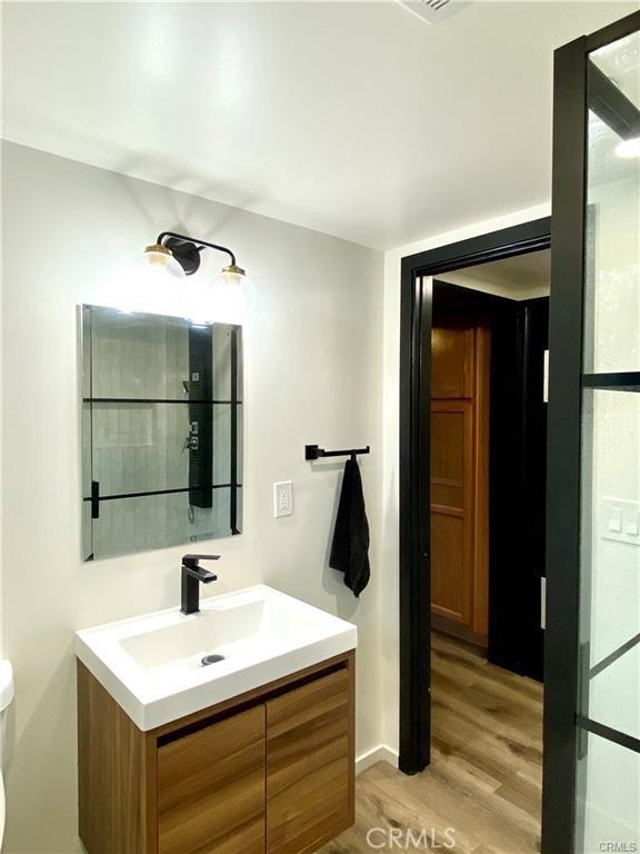 bathroom featuring vanity, hardwood / wood-style floors, and toilet