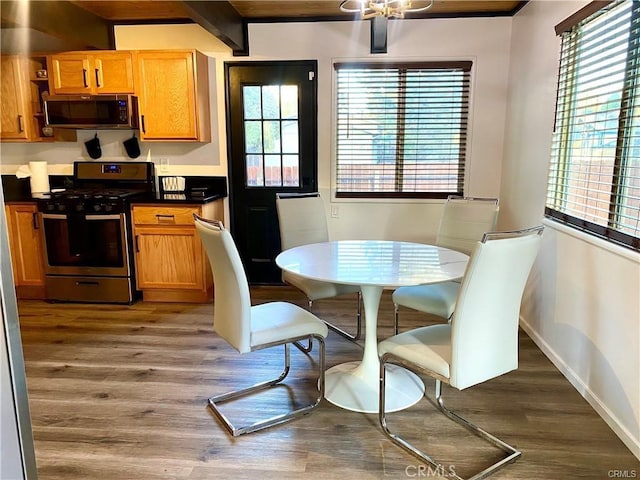 dining room featuring beamed ceiling and dark wood-type flooring