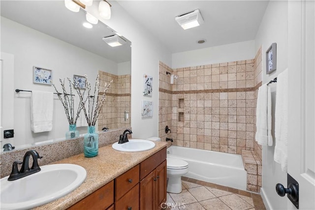 full bathroom featuring vanity, tiled shower / bath, tile patterned floors, and toilet