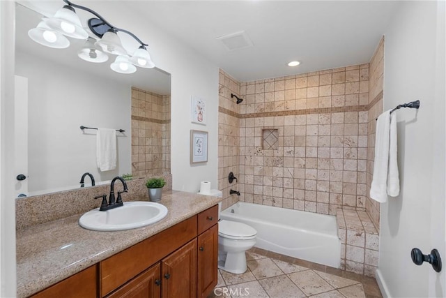 full bathroom featuring tiled shower / bath, vanity, toilet, and tile patterned flooring