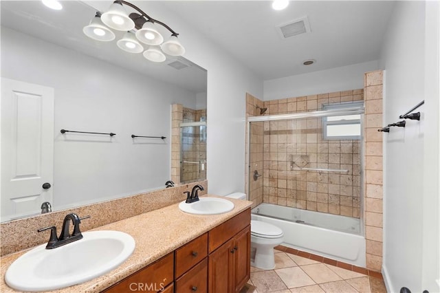 full bathroom with vanity, bath / shower combo with glass door, tile patterned floors, and toilet