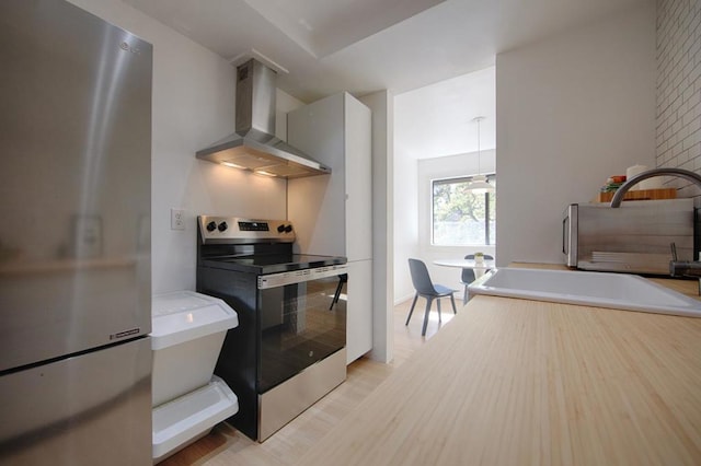 kitchen featuring appliances with stainless steel finishes, sink, light wood-type flooring, and exhaust hood