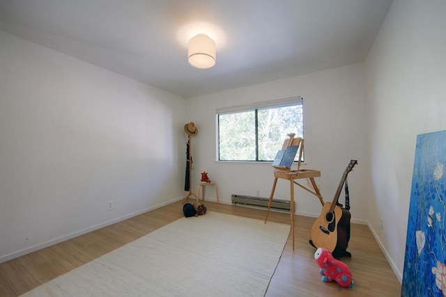 exercise room featuring a baseboard radiator and hardwood / wood-style floors