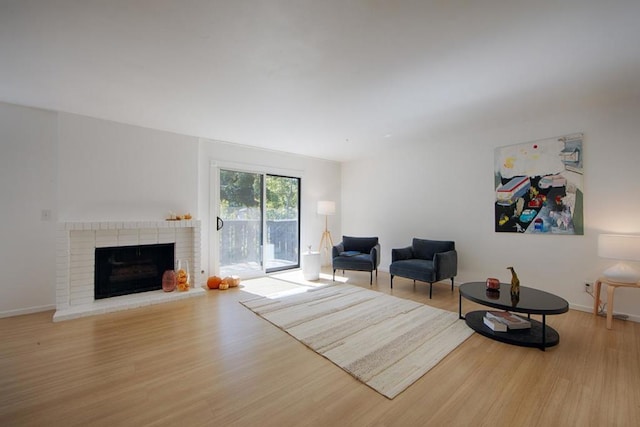 unfurnished living room featuring hardwood / wood-style floors and a brick fireplace